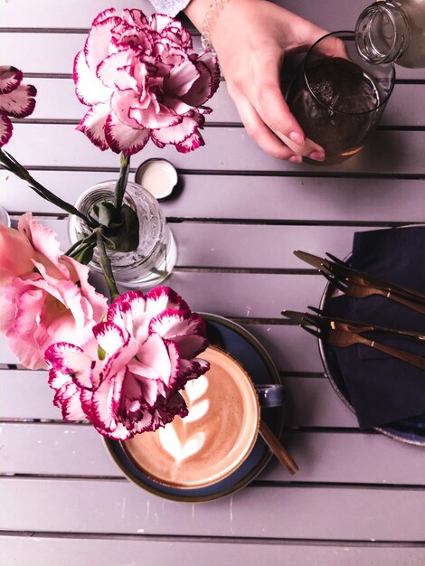 Photo la moitié d'une femme tenant des roses roses dans un café