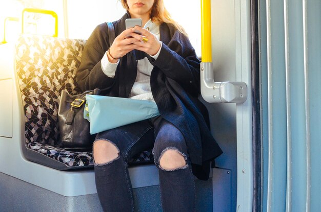 La moitié d'une femme utilisant un téléphone pendant un voyage en train