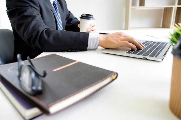 La moitié d'un homme d'affaires travaillant sur un ordinateur portable au bureau