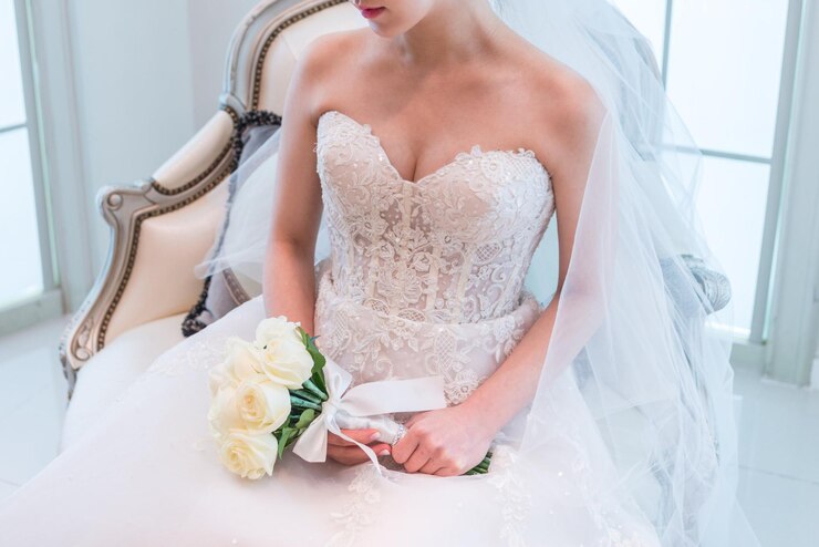 Photo la moitié de la mariée avec un bouquet assise sur une chaise