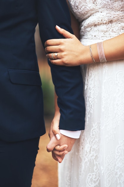La moitié de la mariée se tenant par la main