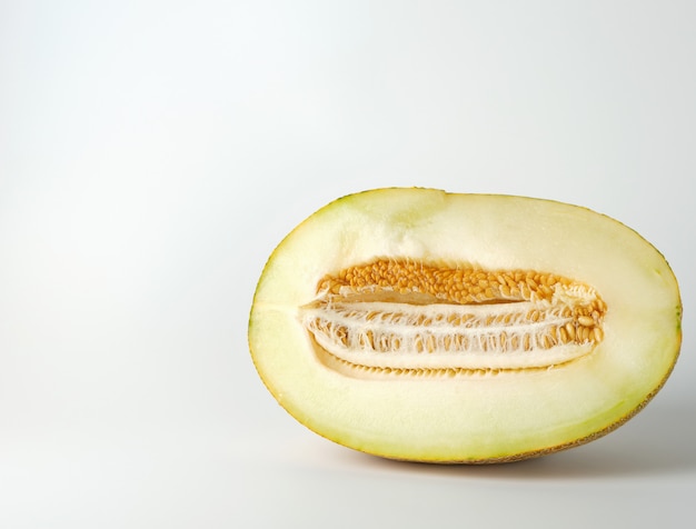 La moitié de melon jaune mûr avec des graines isolées