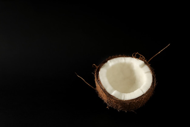 La moitié de la noix de coco fraîche sur fond noir