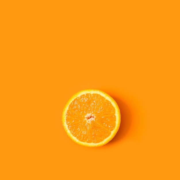 La moitié orange dans une vue de dessus sur un fond orange avec copie espace