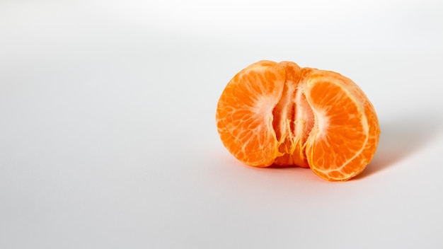 La moitié d'une orange est sur un fond blanc