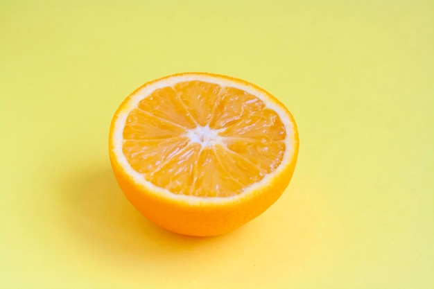 Moitié orange mûre sur une table jaune