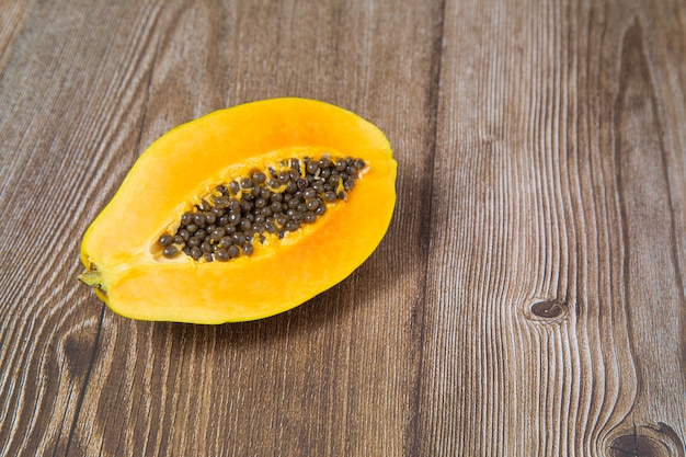 La moitié d'une papaye tranchée, sur une table en bois