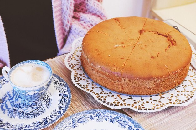 Photo la moitié d'une personne assise à côté du café et du gâteau sur la table