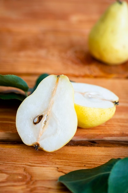 La moitié d'une poire jaune mûre juteuse sur un gros plan de fond en bois