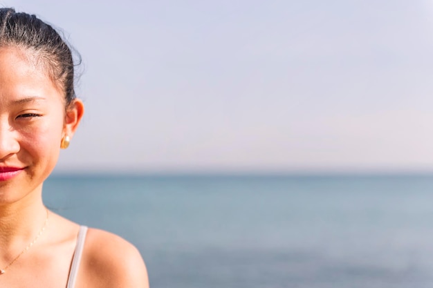 La moitié d'un portrait d'une jeune femme asiatique souriante heureuse