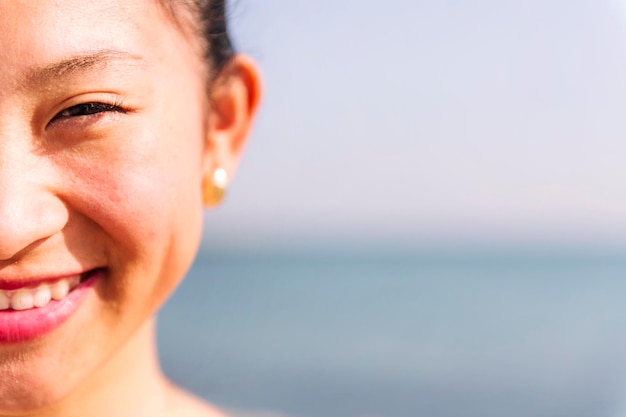 La moitié d'un portrait d'une jeune femme asiatique souriante heureuse