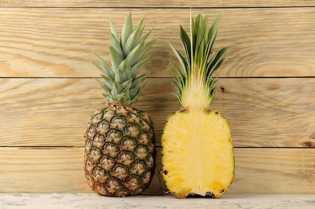 Moitiés d'ananas mûrs frais sur fond de bois naturel fruits d'été