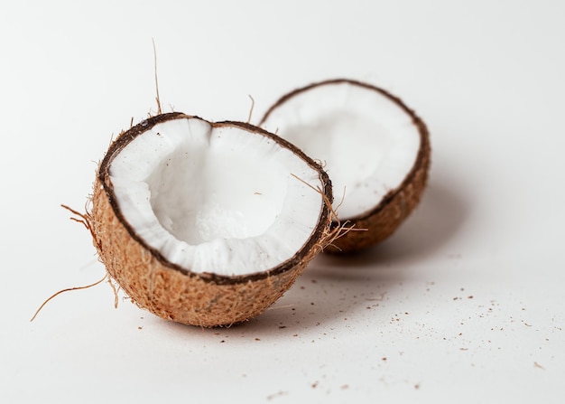 Les moitiés de noix de coco coupent des morceaux de nourriture exotique