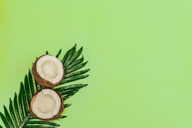 Des moitiés de noix de coco crue fraîche sur fond vert. Vue de dessus, pose à plat