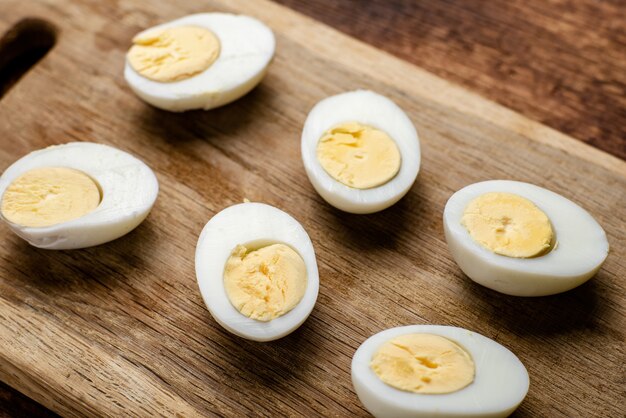 Moitiés d'œufs de poule bouillis sur un fond en bois.