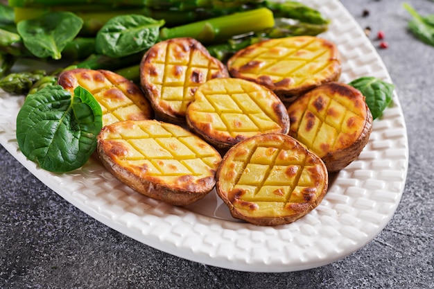 Moitiés de pommes de terre au four et d'asperges. Menu diététique. Nourriture saine. Cuisine végétalienne.