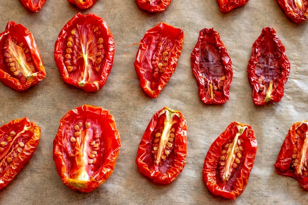 Moitiés de tomates séchées au soleil ou séchées vue de dessus différentes formes et tailles graines vers le haut