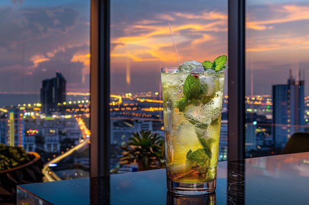 Un mojito apprécié dans un salon sur le toit avec des lumières de la ville en arrière-plan