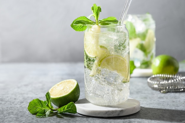 Mojito au citron vert, menthe et glaçon sur fond gris