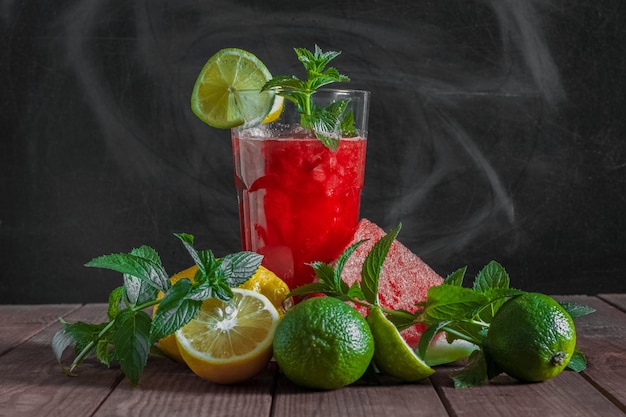 Mojito pastèque dans un verre transparent fruits et menthe sur fond sombre