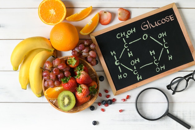 Molécule de glucose sur tableau noir avec mélange de fruits frais