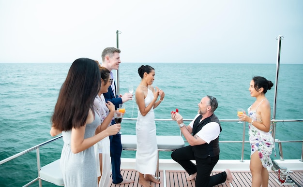 Le moment approprié pour un homme blanc de proposer d'épouser une femme asiatique sur un yacht flottant