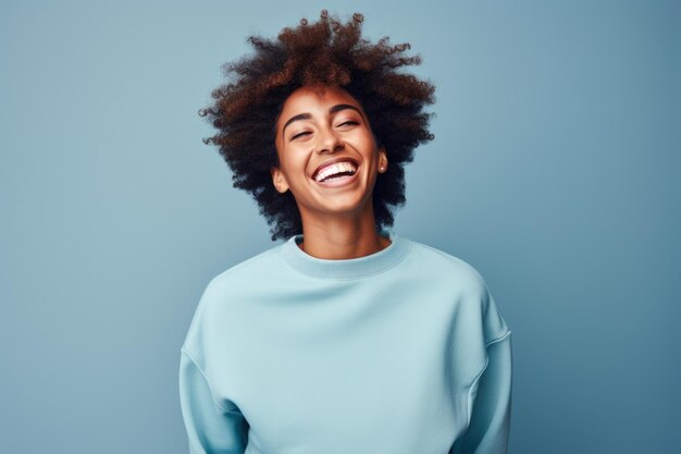 Photo le moment candide d'une jeune femme sur un fond de studio bleu