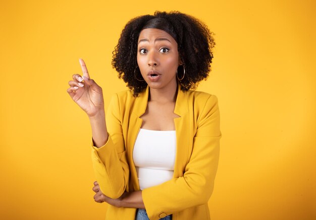 Photo le moment d'eureka a inspiré une dame noire émotionnelle pointant le doigt vers le haut et s'exclamant en regardant la caméra sur