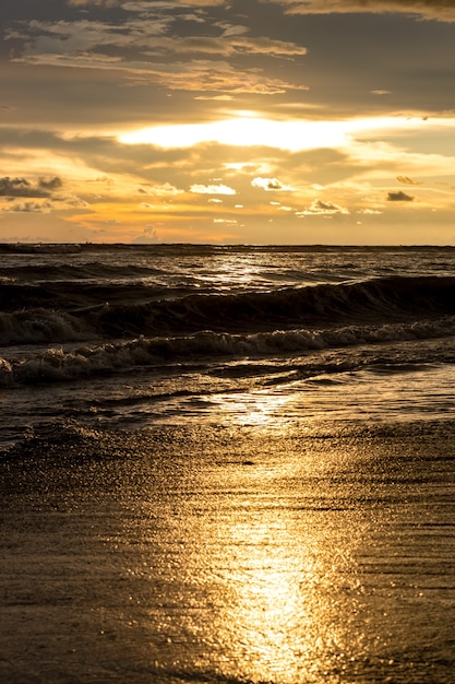 Moment d'heure d'or de coucher du soleil dans la plage de mer avec la lumière du soleil reflétée