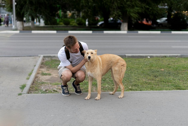 Photo un moment réconfortant un homme agenouillé à côté d’un chien brun