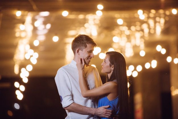 Moment romantique en plein air dans la ville. un rendez-vous romantique. couple d'amoureux sur la ville de nuit. histoire d'amour dans le style de la rue. passion couple amoureux se dresse contre les lumières de la ville de nuit