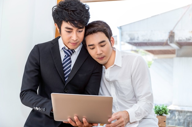 Moment romantique et relaxant.Couple homosexuel asiatique dans une suite de shopping en ligne avec un ordinateur portable ensemble à la maison.Concept gay LGBT.