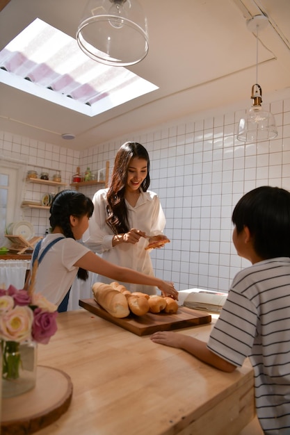 Moments heureux en famille lorsque les enfants aident maman à cuisiner dans la cuisine