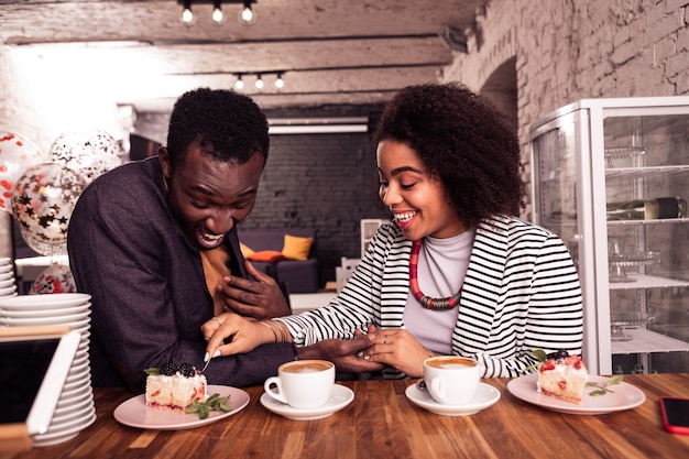 Moments romantiques. Joyeux couple heureux de manger un gâteau tout en passant un bon moment ensemble