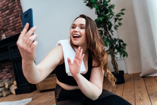 Moments de vie d'une jeune femme à la maison. Femme faisant des exercices de sport dans le salon