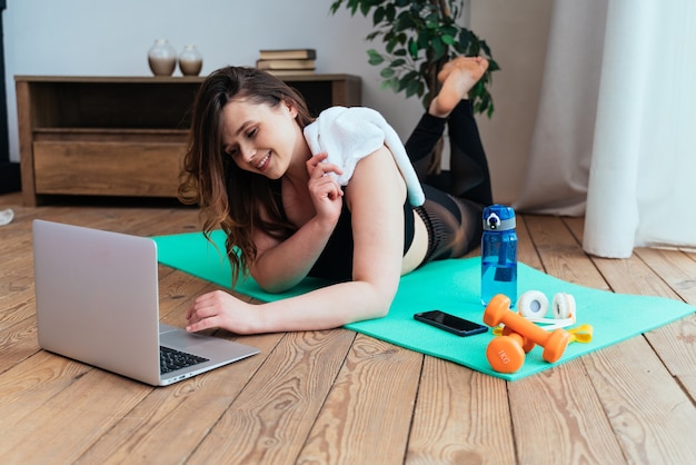 Moments de vie d'une jeune femme à la maison Femme faisant des exercices de sport dans le salon