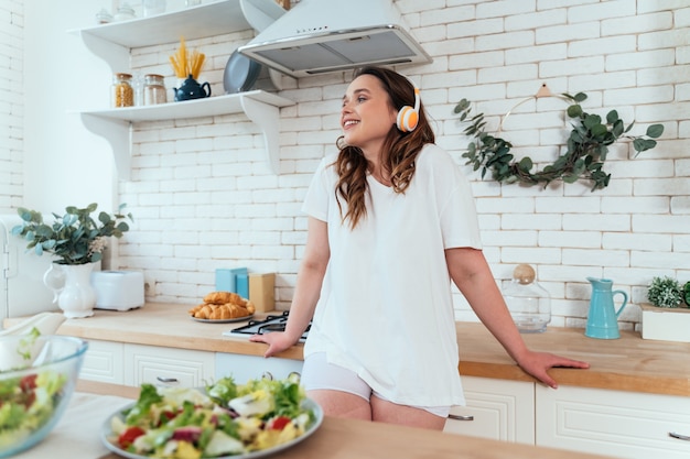 Moments de vie d'une jeune femme à la maison. Femme préparant une salade dans la cuisine