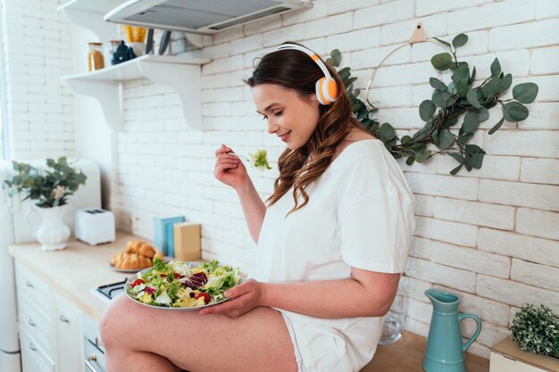 Moments de vie d'une jeune femme à la maison. Femme préparant une salade dans la cuisine