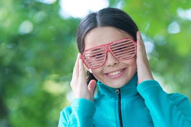 Mon accessoire de mode préféré. Une fille heureuse porte des lunettes fantaisie. Petit sourire d'enfant avec un look de fête. Vacances d'été. Mode et style. Lunettes tendance. Lunettes de mode que vous voulez porter.