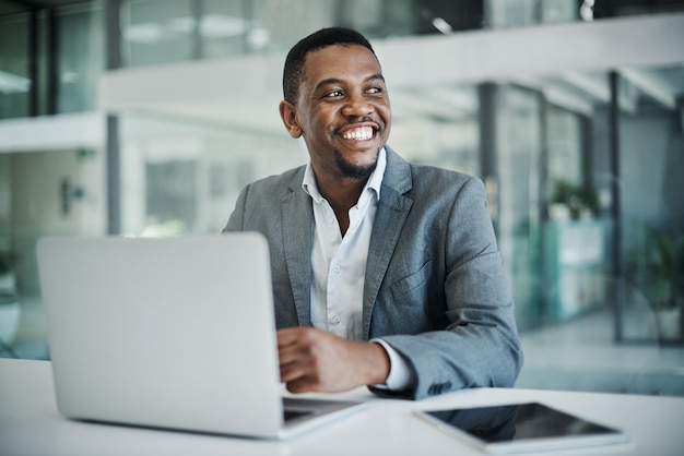 Mon objectif final pour cette entreprise est de se rapprocher Photo d'un beau jeune homme d'affaires assis seul dans son bureau et utilisant son ordinateur portable