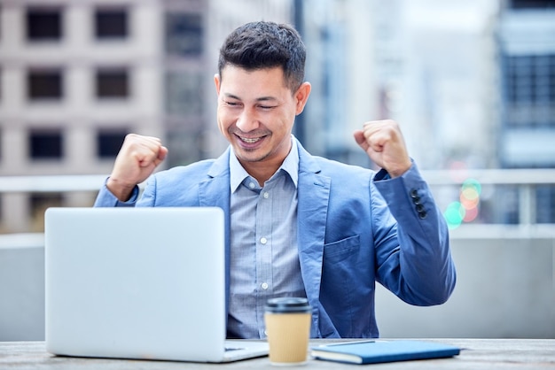 Mon succès parle de lui-même Photo d'un jeune homme d'affaires qui applaudit tout en utilisant un ordinateur portable au travail