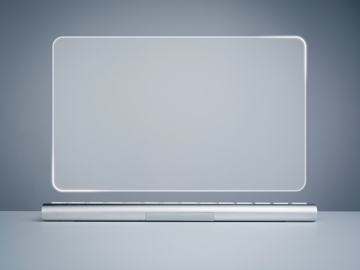 Photo moniteur de bureau à écran virtuel vierge et clavier argenté moderne sur un bureau blanc et fond gris. maquette de l'espace vide sur l'écran virtuel incurvé de transparence, futur concept d'arrière-plan technologique.