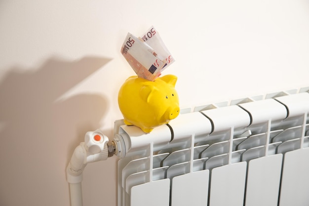 Monnaie en euros et tirelire sur le radiateur de chauffage