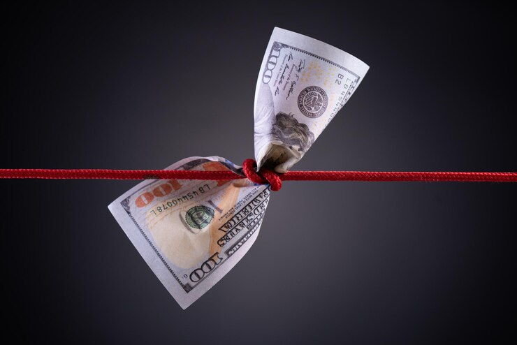 Photo monnaie en papier attachée à une corde sur un fond gris