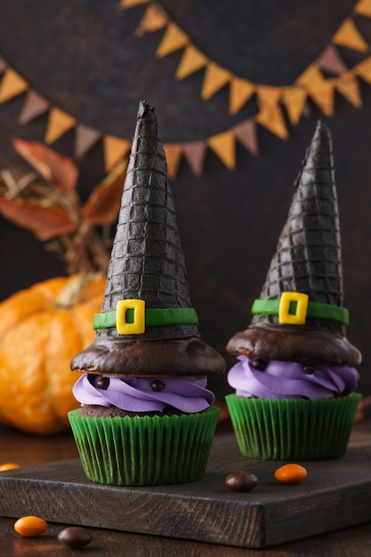 Monstres de cupcake Halloween avec des chapeaux de sorcière et des bonbons