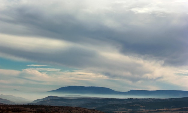 Montagne brumeuse et nuages dans le ciel