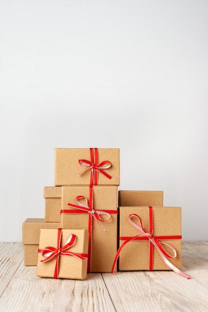 Une montagne de cadeaux dans des boîtes en carton se trouve sur une table en bois blanc copie espace boxing day