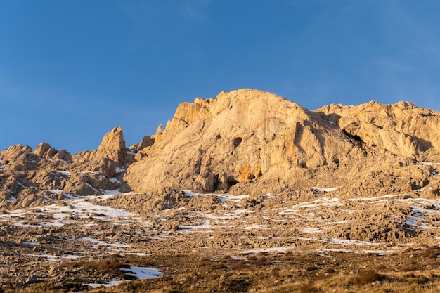 Photo une montagne avec un ciel bleu et de la neige au sol