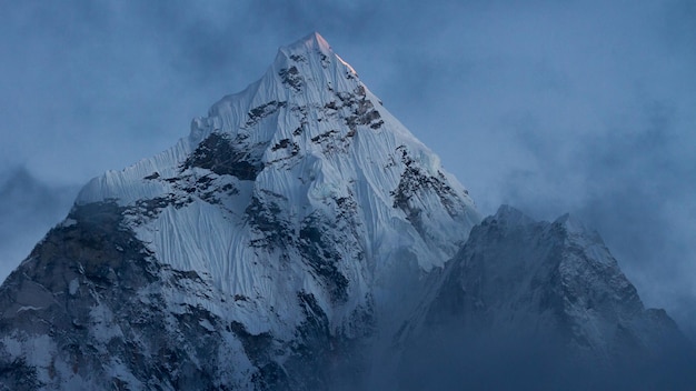 une montagne avec un ciel bleu et des nuages en arrière-plan