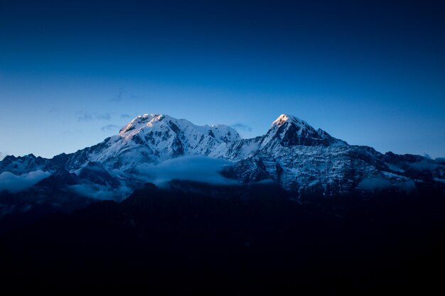 Une montagne avec un ciel bleu et le soleil qui brille dessus